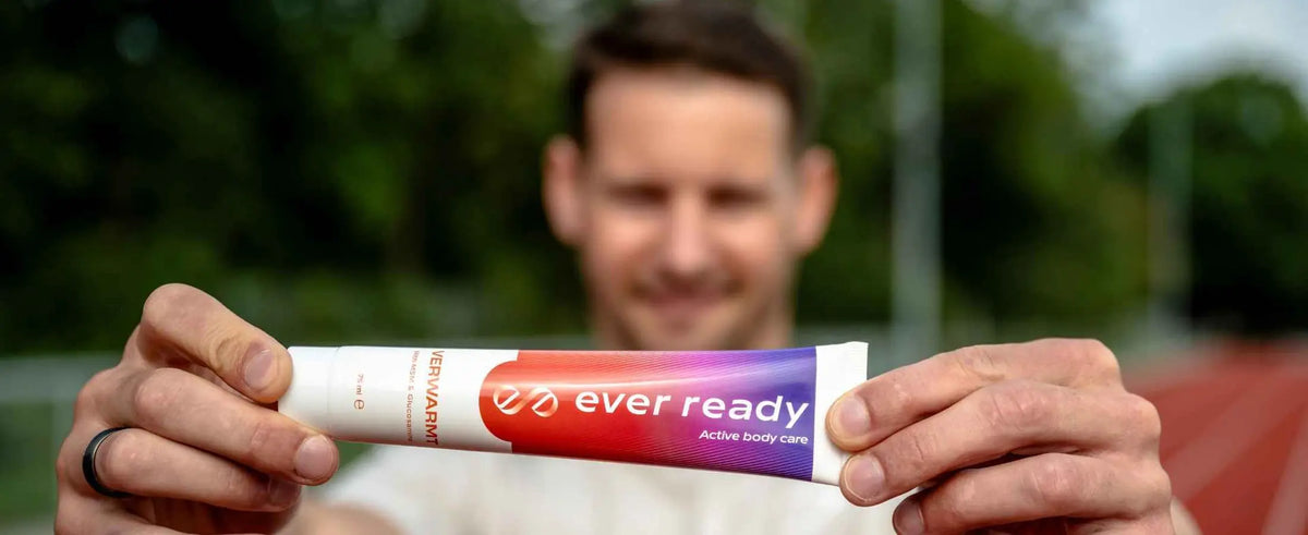 Hardloper houdt een tube Ever Ready warmte crème vast