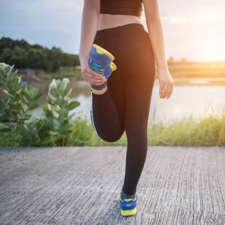 Jonge vrouw warmt zich buiten op om in de ochtend te gaan hardlopen