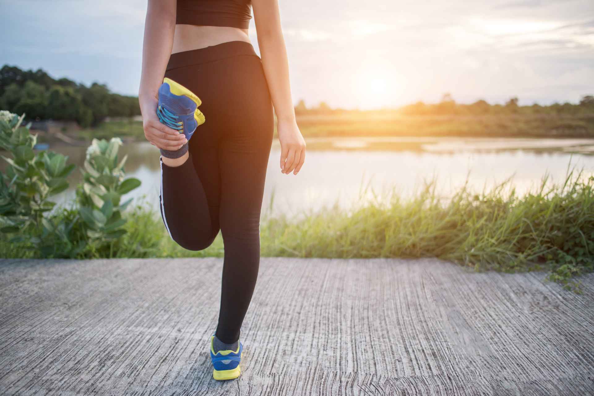 Jonge vrouw warmt zich buiten op om in de ochtend te gaan hardlopen