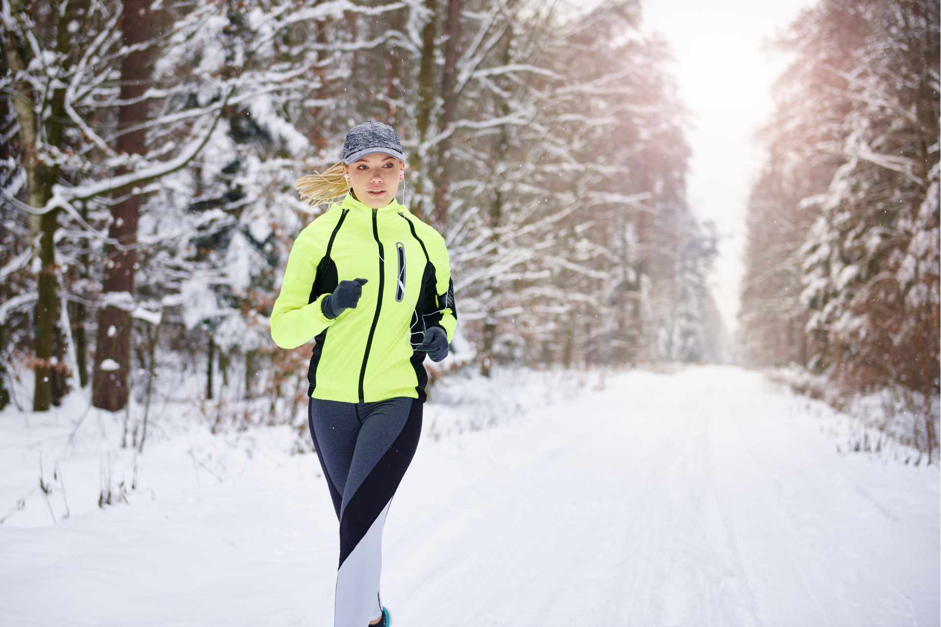 vrouw doet aan hardlopen in de winter. Hardlopen door de sneeuw met de juiste kleding