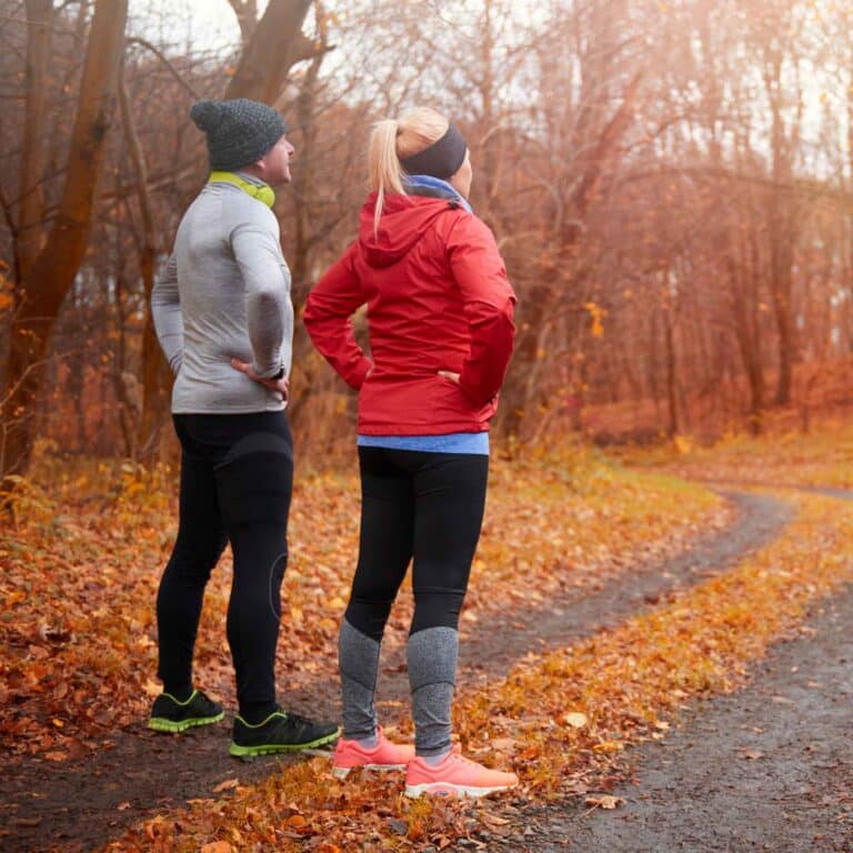 Man en vrouw bewegen in de herfst in het bos