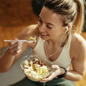 Vrouw eet gezonde voeding tijdens het sporten